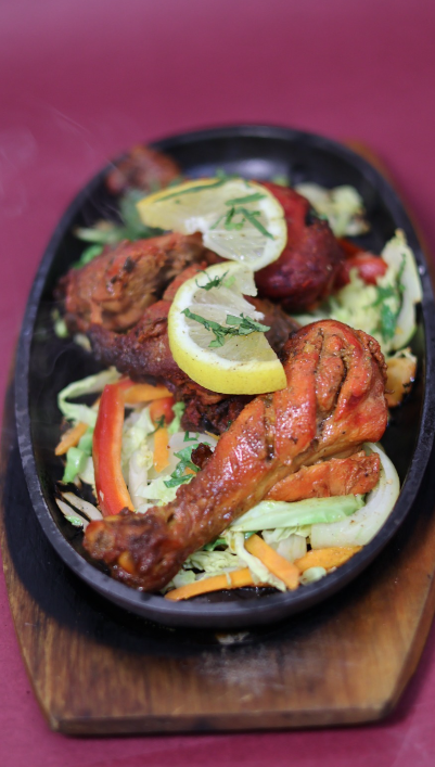 Sizzling hot tandoori chicken served with lemon and fresh vegetables