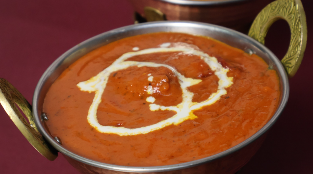 Aromatic Chicken Tikka Masala served in a traditional metal bowl